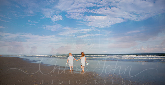 - Siblings walking up the beach